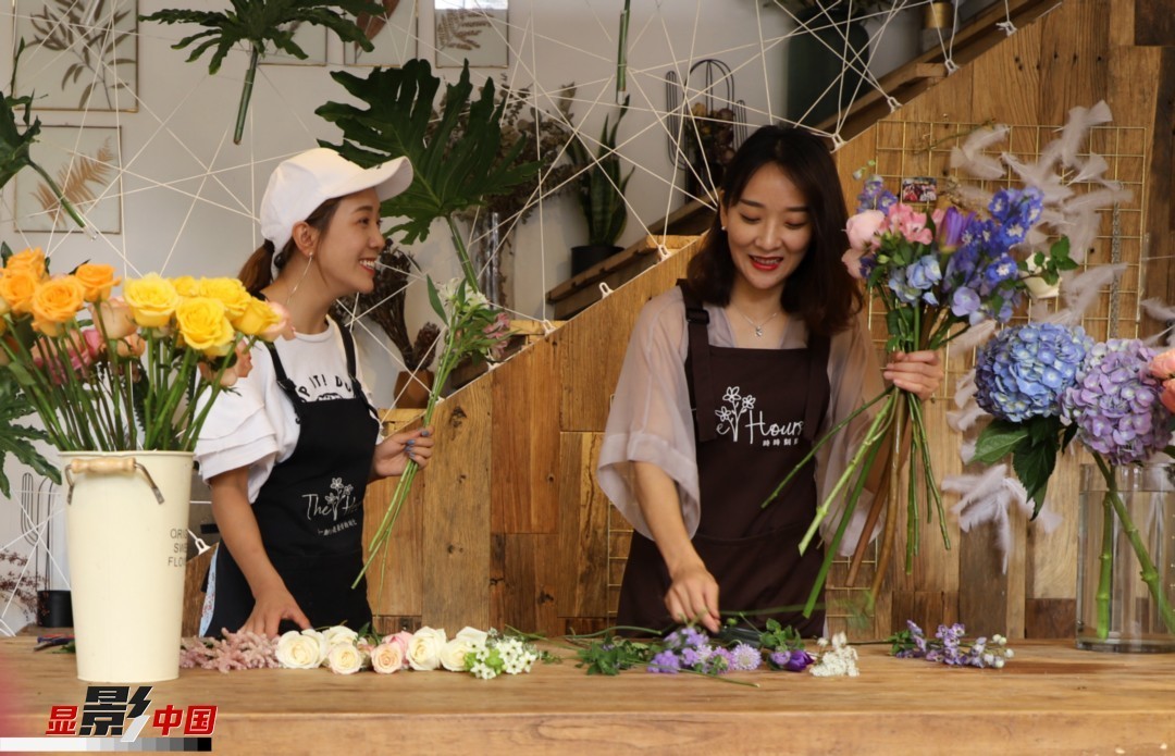 “昆明是鮮花的原產(chǎn)地，有亞洲最大的鮮切花交易市場，可以說具備開花店的天時(shí)地利；另外和很多女孩一樣，我從小也就有開花店的夢想！”說起當(dāng)初的決定，王黎媛說一是因?yàn)閴粝?，另外也跟昆明這個(gè)城市產(chǎn)花、賣花的“基因”有關(guān)。圖為王黎媛和同事在制作花束。新華網(wǎng) 周亞平/攝 念新洪/文